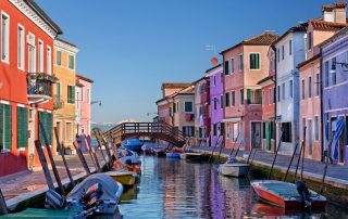 Colored buildings reflecting on the water in Burano, Italy.