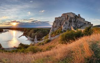 Devin Castle in Slovakia during golden hour with the sun setting over the Danube River. An easy day trip from Bratislava!